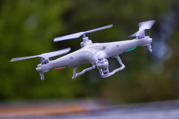 White drone quadcopter taking off from the ground. Soft focus. Motion blur.
