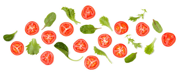 Creative layout made of tomato slices and salad leaves. Flat lay, top view. Vegetables isolated on white background. Food ingredient pattern.