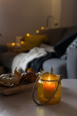 fall halloween hygge scandinavian style decoration with candle, pumpkins and lights