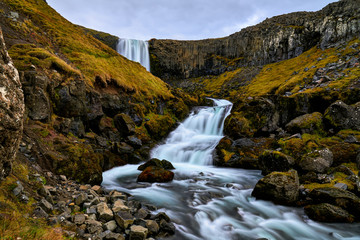 Naklejka na ściany i meble Dramatic Svodufoss waterfall with water of river Laxa dropping ten meters is located in Olafsvik Snaefellsnes which is peninsula in Western Iceland. Here photographed in early October 2019.