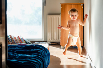 Baby taking her first steps barefoot.