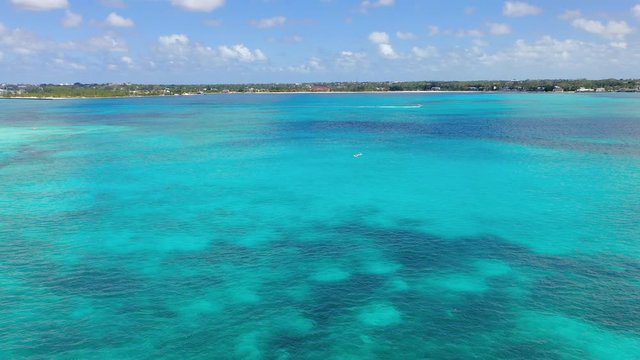 Aerial: Wide Expanse of Tropical Water, Two Paddle Boarders and One Jet Skier Far From Shore - Nassau, Bahamas