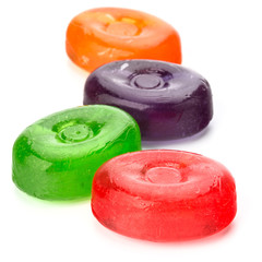 Four colorful fruit hard sugar candies,  boiled sweeties or sugar plums isolated on white...
