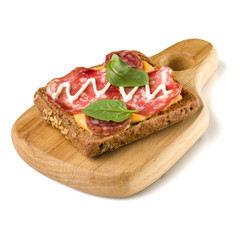 Open  faced sausage sandwich canape or crostini on a wooden serving board  isolated on white background closeup.
