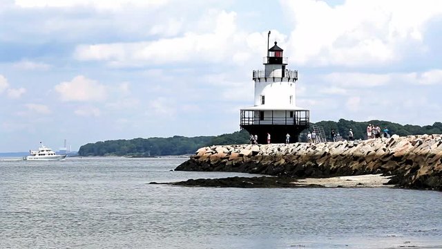 A small yacht passing the Spring Point Ledge Lighthouse in South Portland Maine.