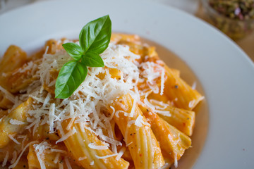 Food photography of an Italian pasta dis with a tomato and cream sauce with artichokes and parmesan cheese
