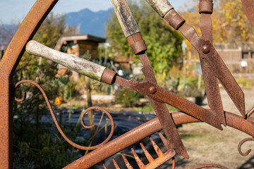 Scrap metal art. Close up of community garden gate made out of garden tools.  