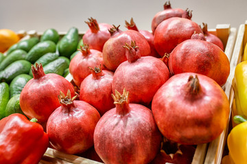 Fresh fruit stall concept, pile of pomegranate in the black box basket from farmer for sale, red fruit for texture background around the market