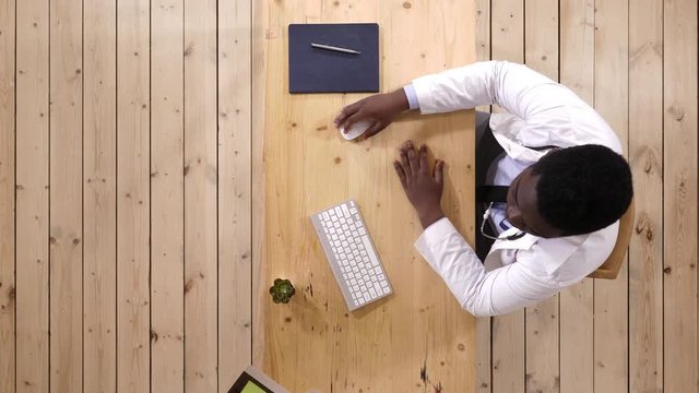 Doctor working on desk with laptop computer.