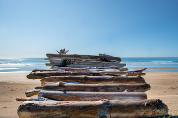 A driftwood stairway across the beach to the ocean