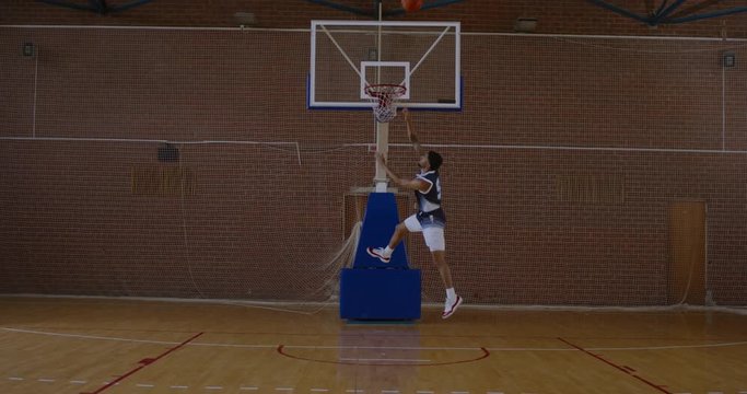 WIDE African American black college male basketball player misses the dunk during practice on the indoor court. 4K UHD 120 FPS SLOW MOTION RAW Graded footage