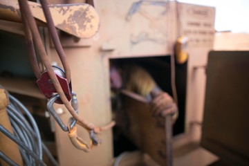Obraz premium Rope access miner working inside the confined space at mean time connecting back up safety rope with three two one pulleys system on his harness for safety rescue precaution construction mine site