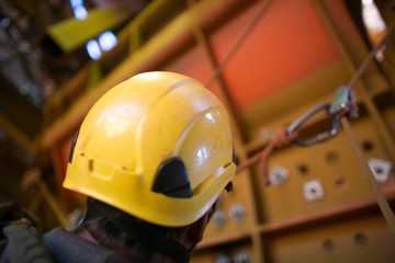 Picture of rope access worker head wearing a yellow fall protection safety helmet while he is...