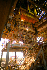 Rope access miner wearing full safety harness, helmet, mask face shield protection uniform abseiling working on twin ropes commencing hot work gouging construction mine site Perth, Australia
