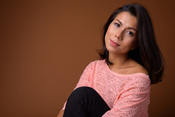 Portrait of beautiful multi ethnic woman sitting on the floor