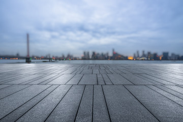 night view of empty brick floor front of modern blurred building