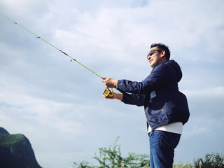 Asian man fishing with nature background, lifestyle concept.