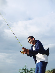 Asian man fishing with nature background, lifestyle concept.