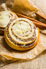 Fresh cinnamon buns on the rustic wooden background. Selective focus. Shallow depth of field.