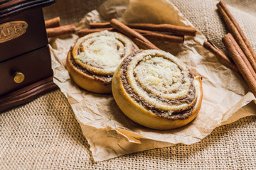 Fresh cinnamon buns on the rustic wooden background. Selective focus. Shallow depth of field.