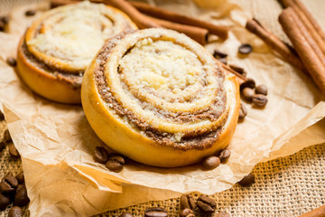 Fresh cinnamon buns on the rustic wooden background. Selective focus. Shallow depth of field.
