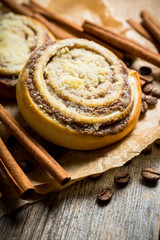 Fresh cinnamon buns on the rustic wooden background. Selective focus. Shallow depth of field.