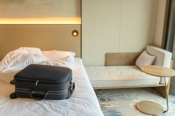 Fototapeta na wymiar blue luggage on the bed of a hotel room