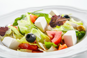 Macro Shot of Greek Salad in Light Plate Isolated on White Background