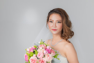 Naklejka premium Asian bride standing and holding a bouquet..