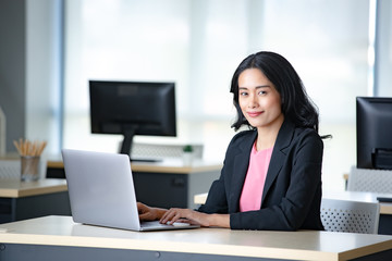 Asian businesswoman using laptop in office..