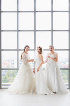 Group of beautiful brides arrange their dress..