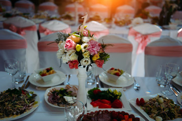 Served festive table, with a variety of dishes, decorated with flowers. Banquet, gala dinner, birthday party wedding anniversary.