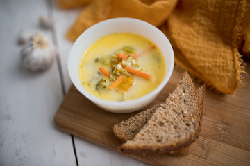 broccoli cheese soup served with toasted bread in a bowl