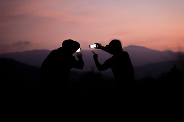 The traveler using the phone with sunset background