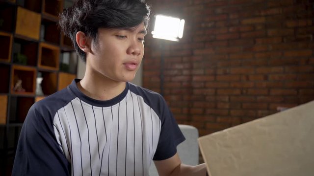 Asian young man making unboxing review recording video for vlog and social media