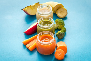 Vegetable and fruits puree for feed babies on blue background