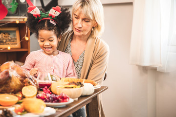 Little Girl Eating  and smile Thanksgiving Celebration Concept. grandmother and granddaughter...