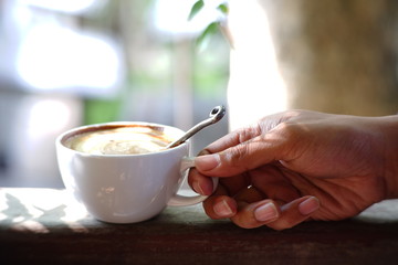 woman holding cup of coffee in her hand