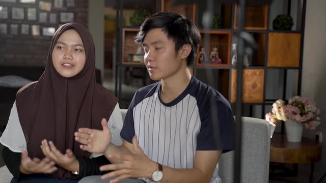 Asian muslim couple blogger recording vlog talking to camera when work at home
