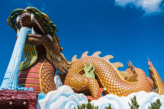 Suphan Buri, Thailand - October 27, 2019: the landmark for Buddhist with gold huge dragon to be worship. Tourists come to visit because they believe in dragon in zodiac at Suphan Buri, Thailand