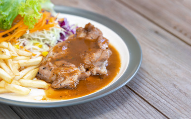 Pork steak with french fries on a white dish