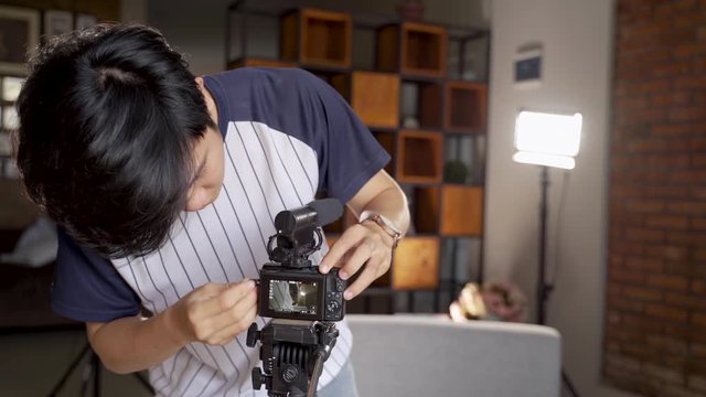 young man vlogger preparing lighting to create their vlog content at home