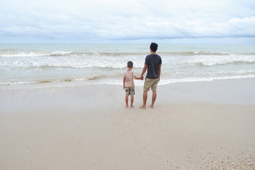 father and son walking on the beach