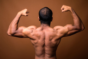 Rear view of muscular Indian man with mustache shirtless