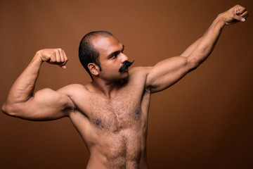 Profile view of muscular Indian man with mustache shirtless