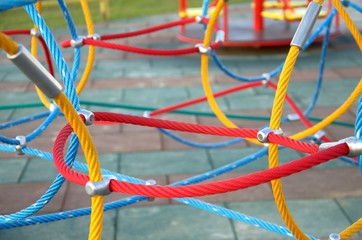 Web of ropes on the Playground, in the Park. The tone is rich, bright. Rope colors: yellow, red, blue. 