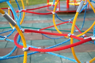 Web of ropes on the Playground, in the Park. The tone is rich, bright. Rope colors: yellow, red,...