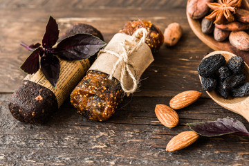 Bunch of mixed gluten free energy bars with dried fruit & various nuts, wooden background. Healthy vegan super food, different fitness diet snacks for sporty lifestyle. Top view, copy space.