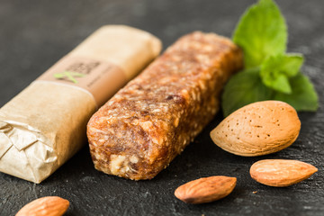 Bunch of mixed almond  bars with dried fruit & various nuts, wooden background. Healthy vegan super food, different fitness diet snacks for sporty lifestyle. Top view, copy space.