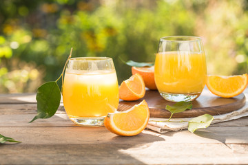 Glass of fresh orange juice,ripe orange fruit and slices on natural .Freshly squeezed orange juice, orange fruit and orange slices.